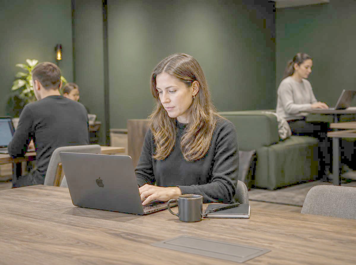Marketing professional working flexibly from a shared workspace lounge